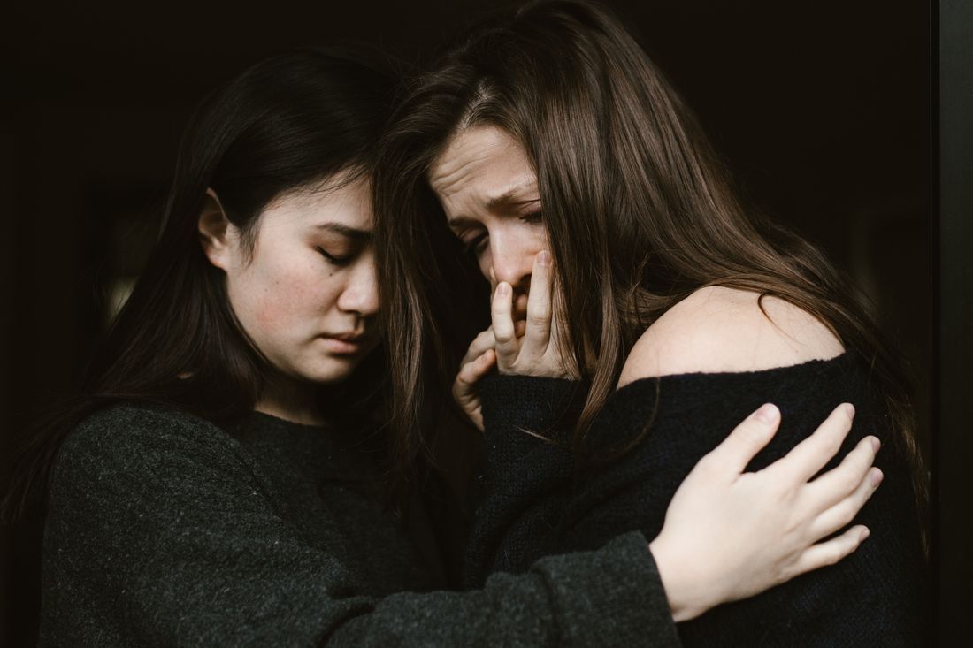 Two women embracing tenderly in shared grief