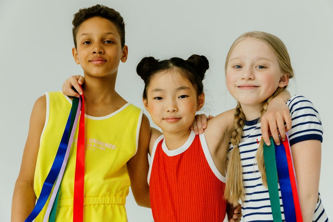 Three children from different backgrounds smiling together