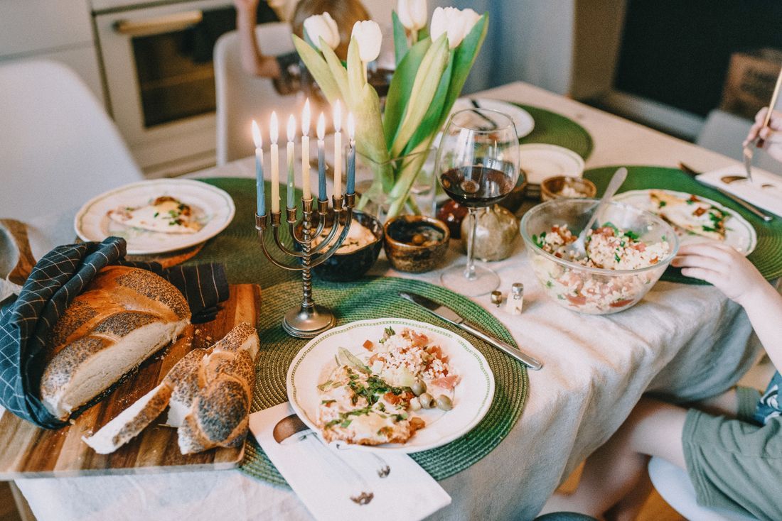 A Shabbat table set with challah and candles