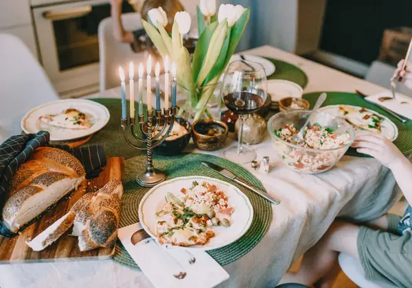 A Shabbat table set with challah and candles