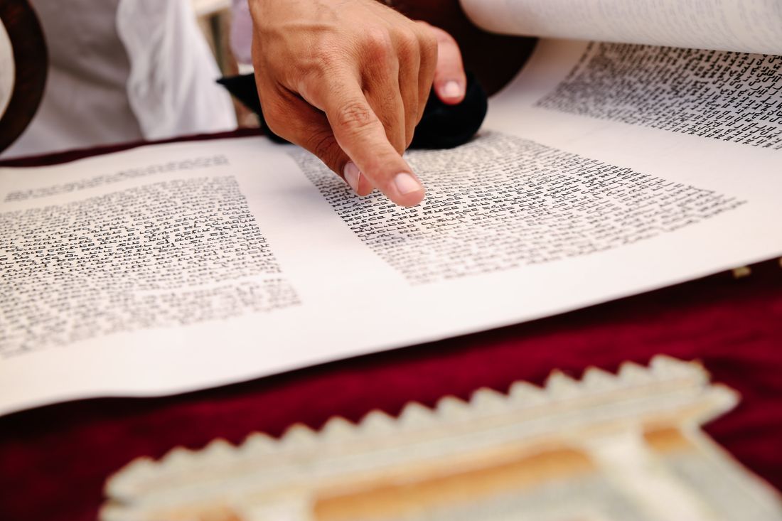 A finger following the sacred Hebrew text of the Torah