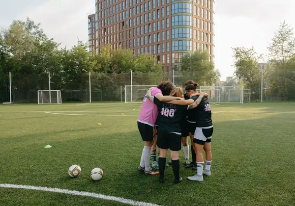A women’s team huddled close together before a match