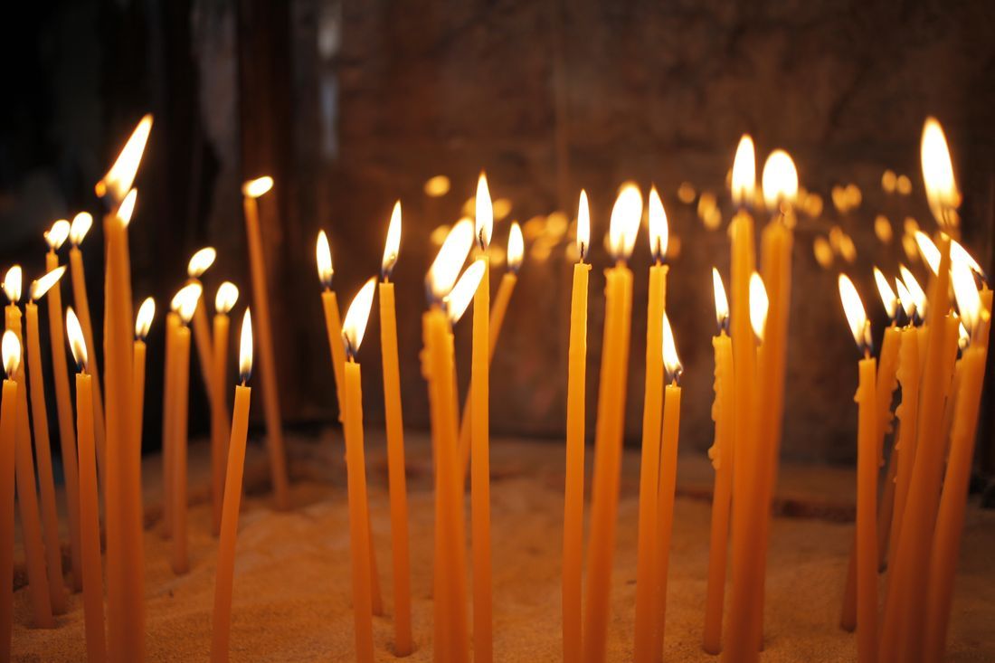 Tall prayer candles glowing warmly in a church