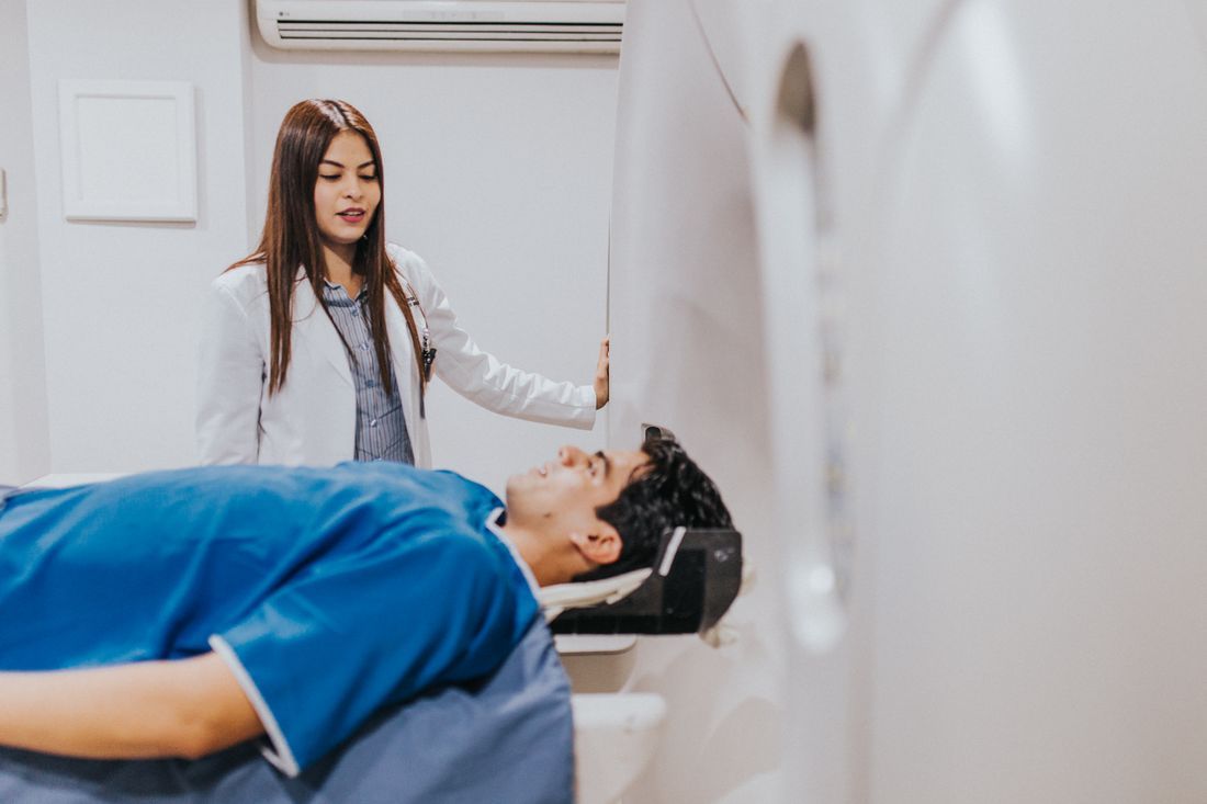 A physician reassuring a patient before an imaging scan