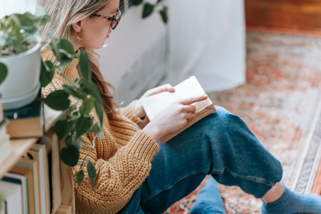 A woman reading quietly by a sunlit window