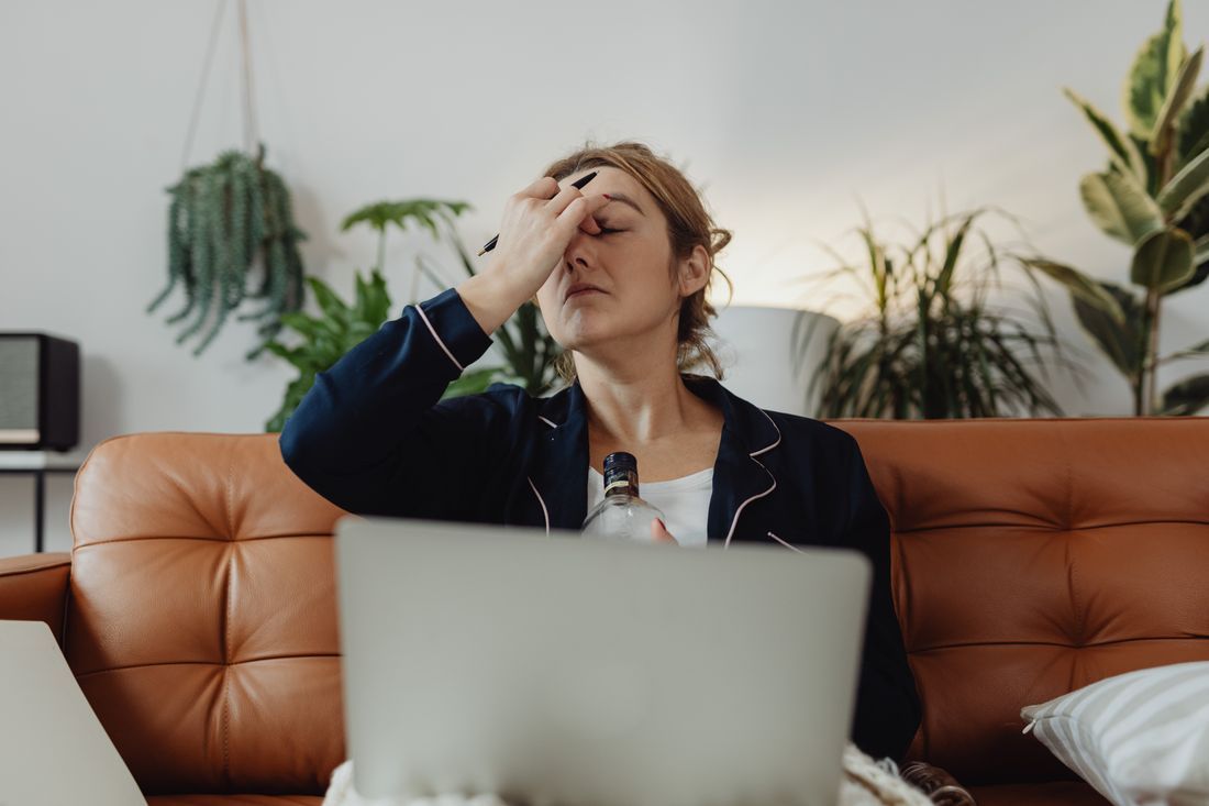 A weary mother resting her head in her hand, carrying the mental load