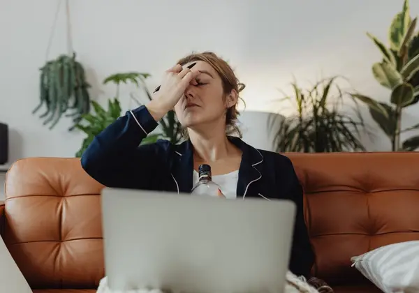 A weary mother resting her head in her hand, carrying the mental load