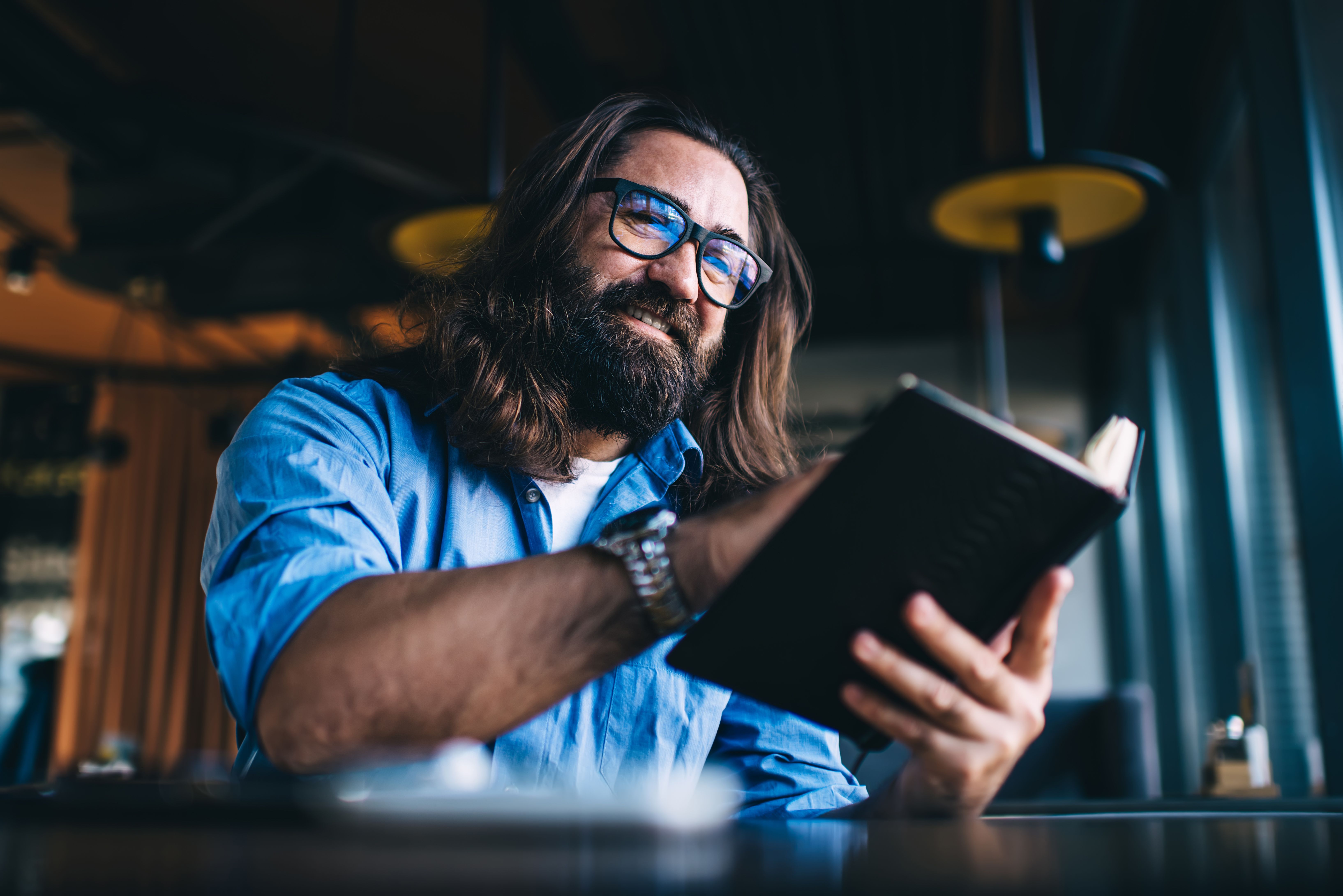 A person leaning close over an open book in quiet study — the moment of seeing what was always on the page, when the Scriptures stop saying a distant 'God' and begin to read 'our Father.'