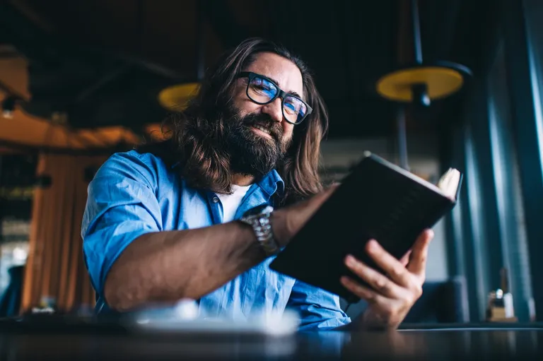 A person leaning close over an open book in quiet study — the moment of seeing what was always on the page, when the Scriptures stop saying a distant 'God' and begin to read 'our Father.'