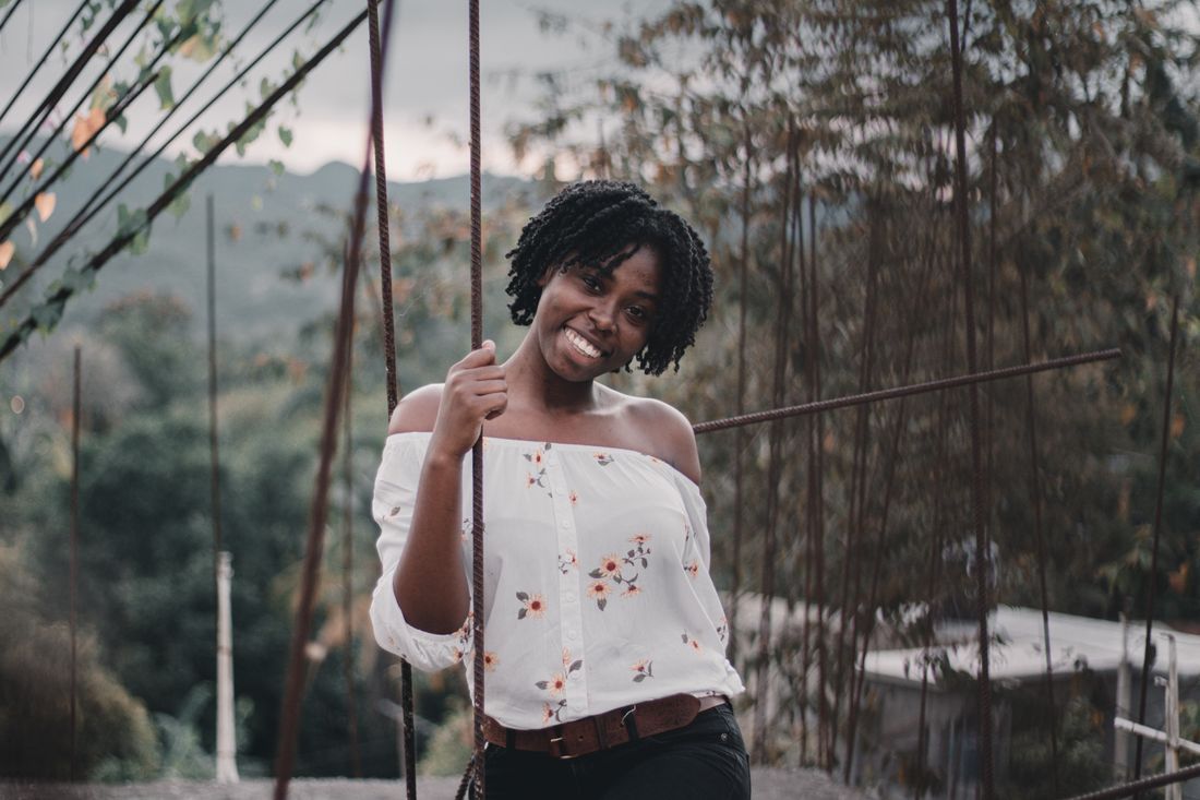 A woman smiling brightly outdoors in a floral top