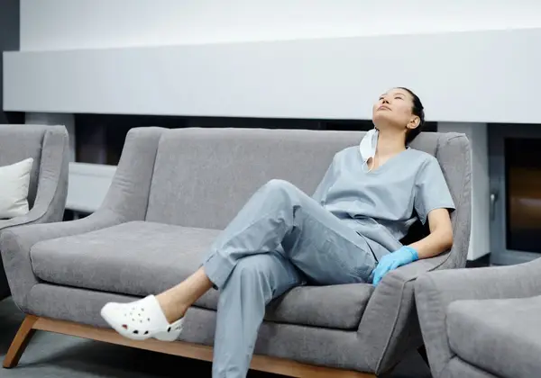 A nurse in surgical gown pausing between procedures