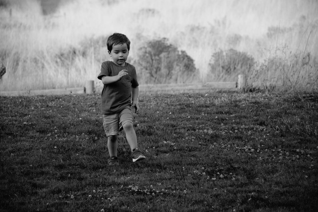 A little boy running freely through an open field