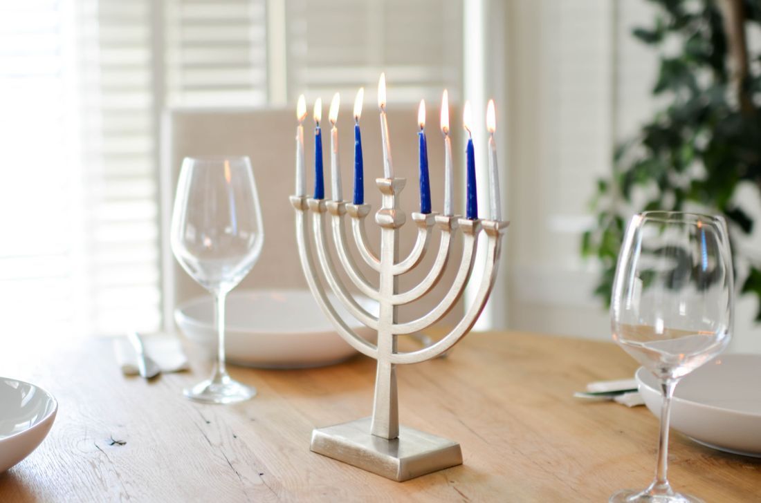 A lit Hanukkah menorah on a table