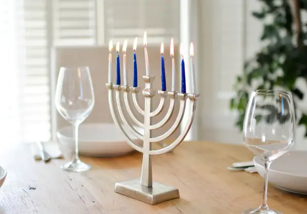 A lit Hanukkah menorah on a table