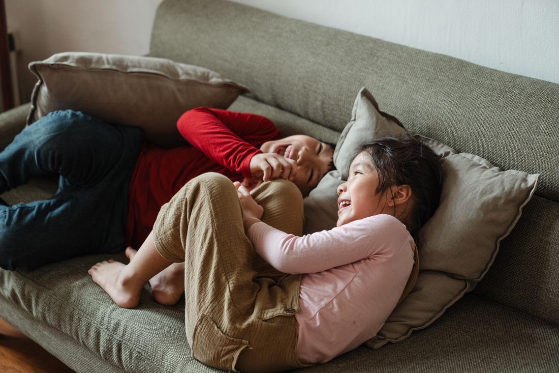 Two children snuggled together, laughing