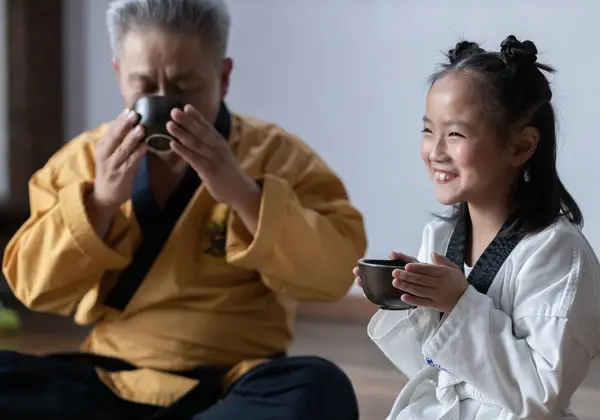 A Korean elder sharing tea with a young girl