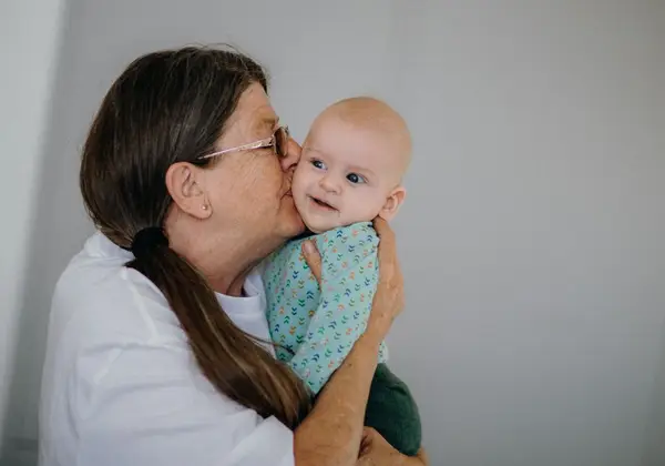 A nursery volunteer tenderly holding a baby