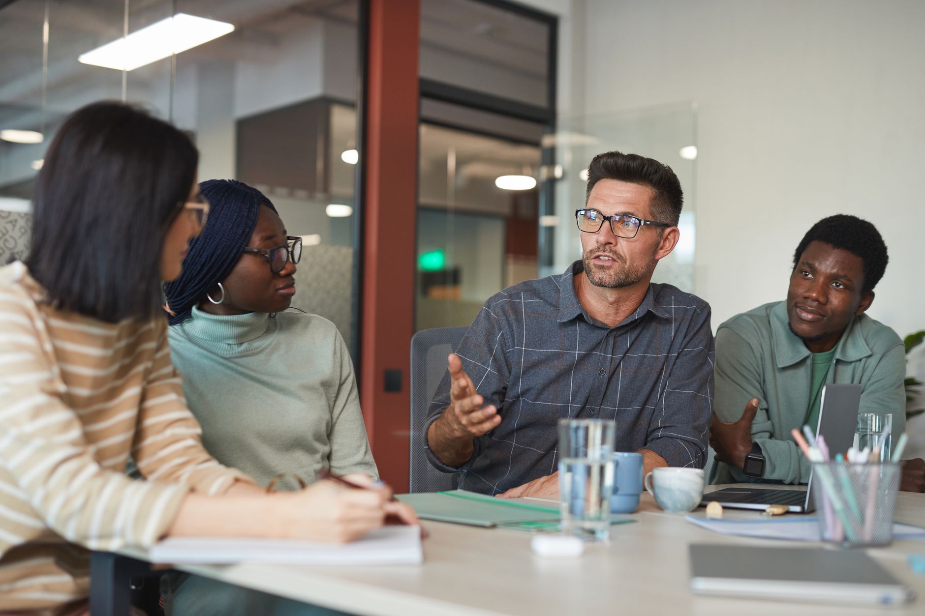 A leader listening and speaking with an engaged, diverse team