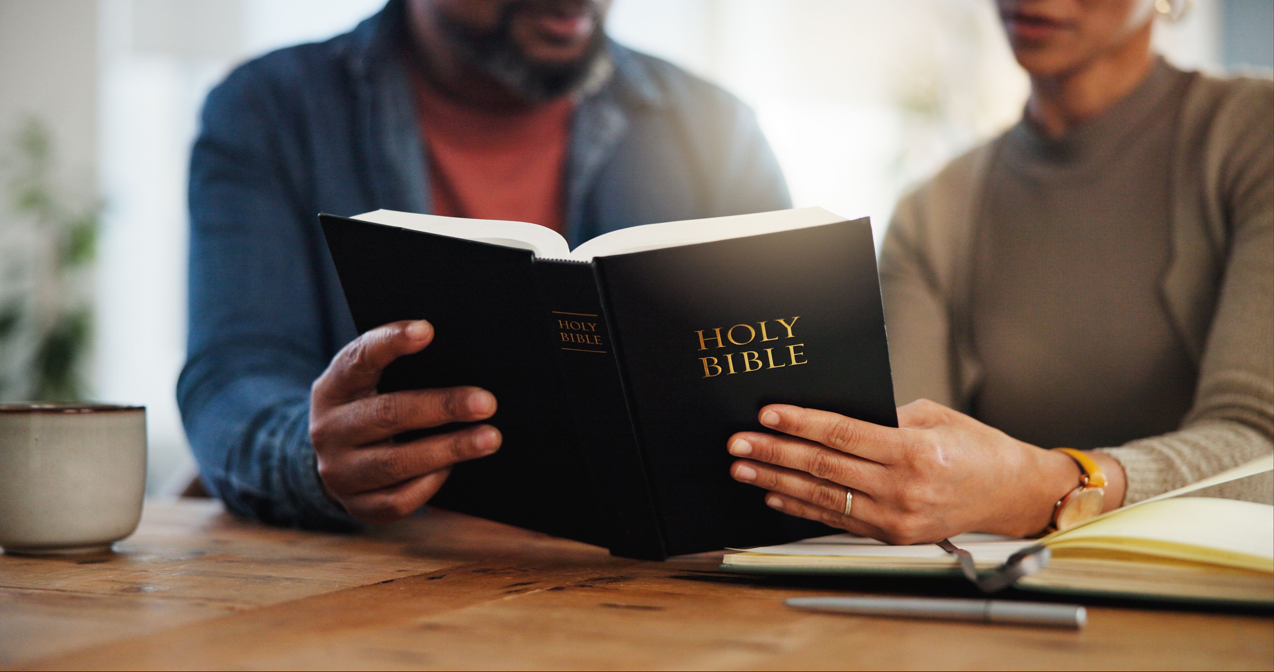 A husband and wife reading the Scriptures together at home — receiving the Father's heart side by side, the picture of a marriage that is not his or hers but ours.