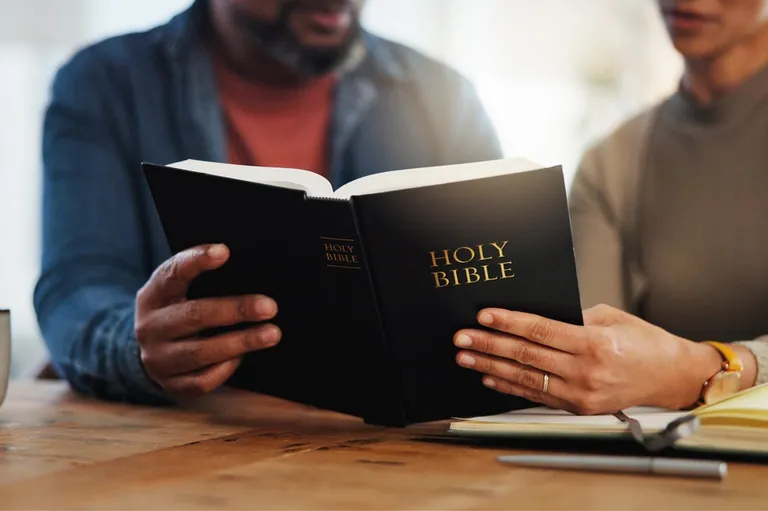 A husband and wife reading the Scriptures together at home — receiving the Father's heart side by side, the picture of a marriage that is not his or hers but ours.