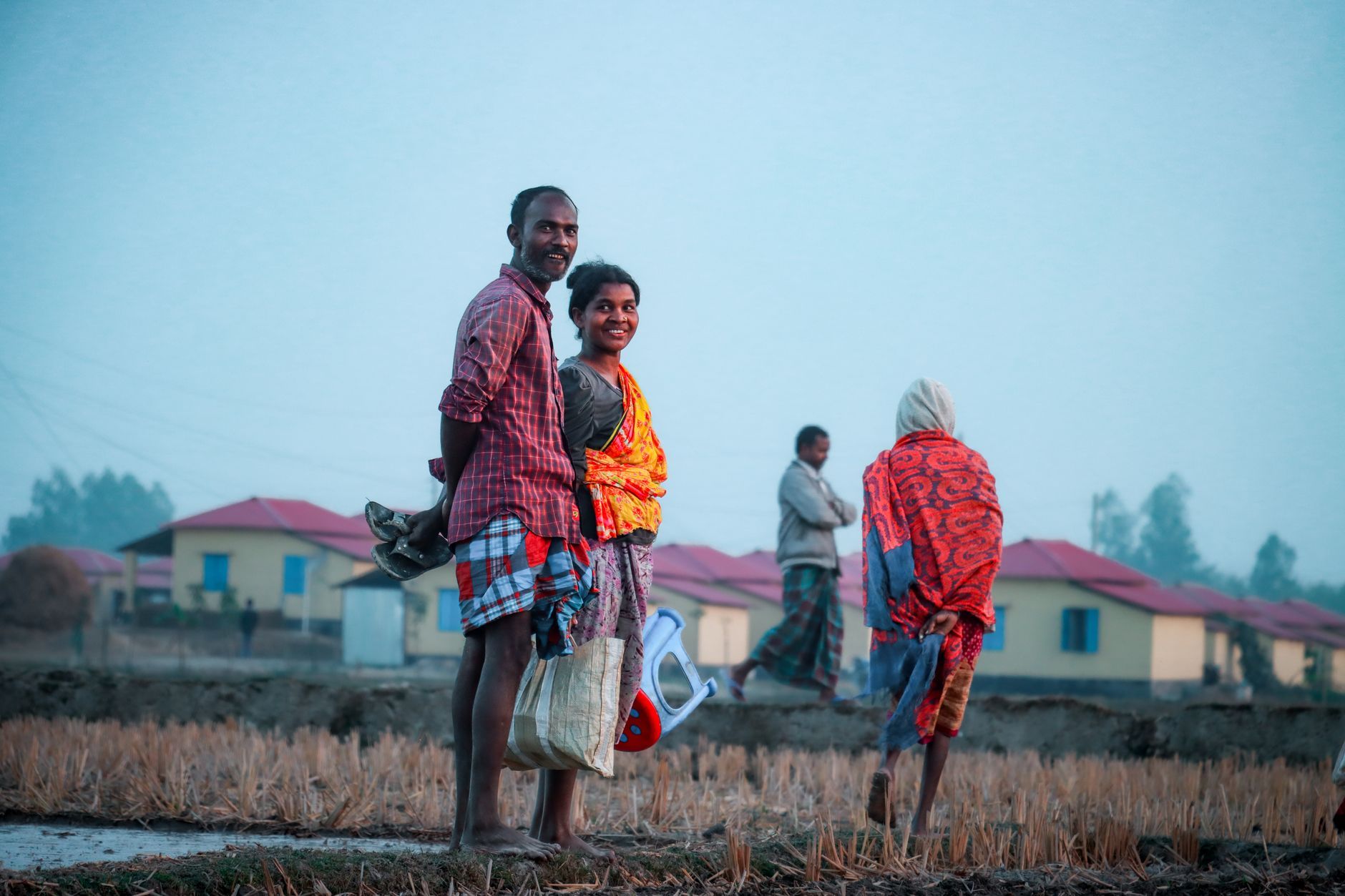 A Bangladeshi rural couple smiling in their village at dusk