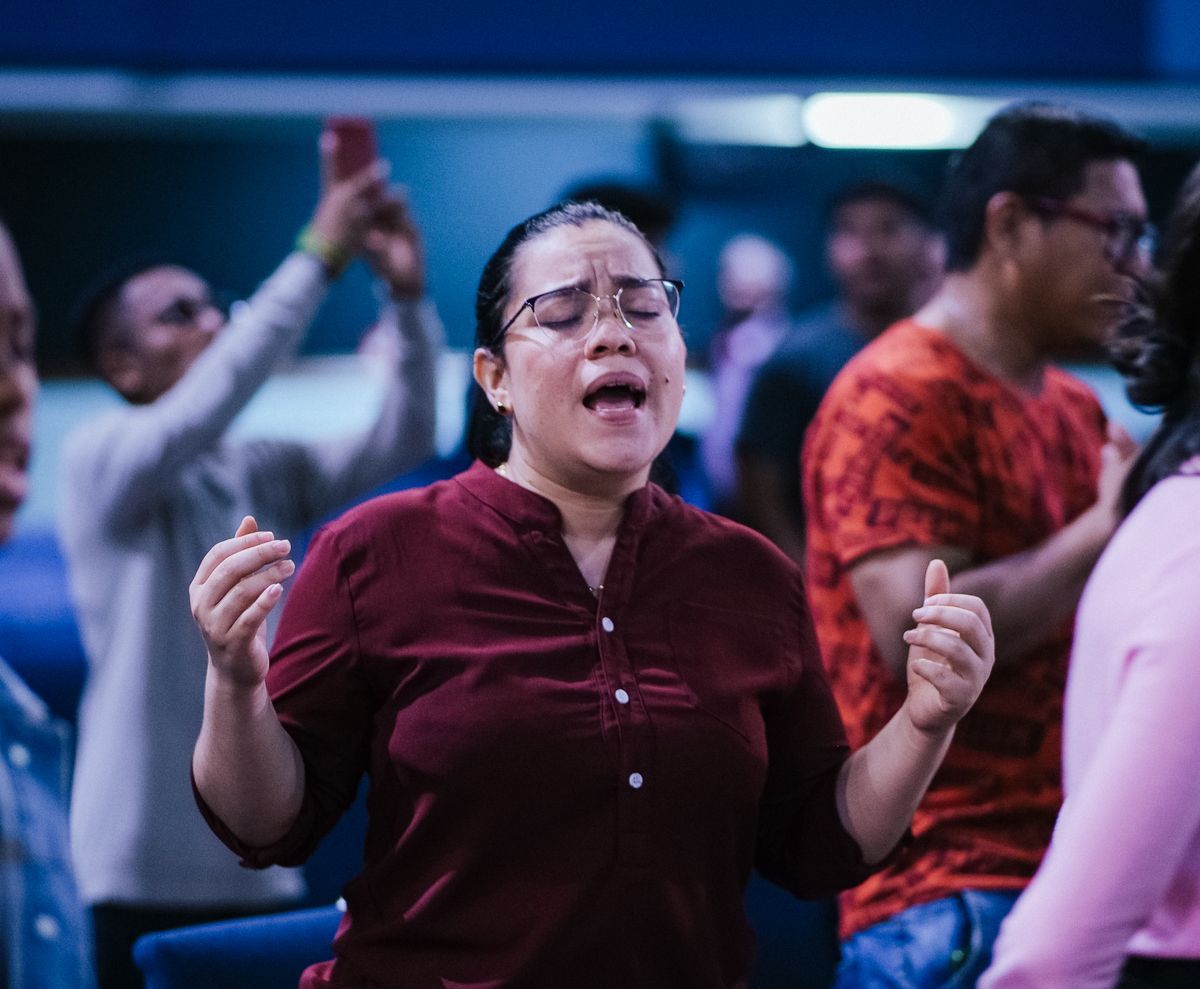 A woman worshipping with her hands lifted during a service