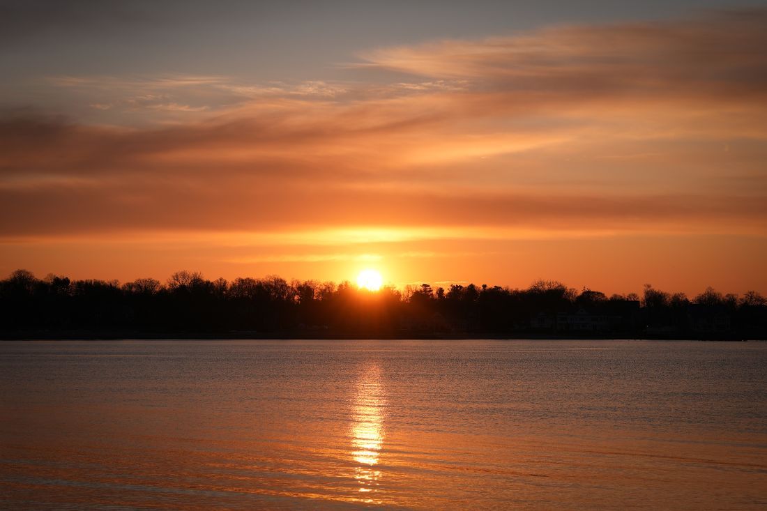 The sun setting warmly over calm water