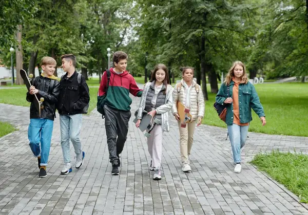 A group of middle schoolers walking together through a park