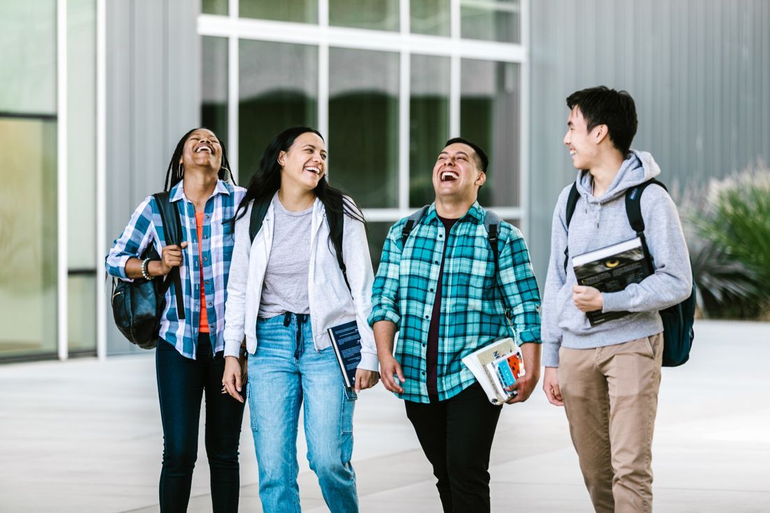 Four young friends walking and laughing together
