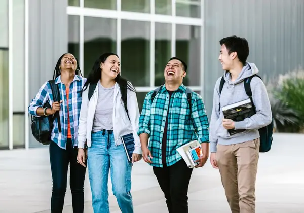 Four young friends walking and laughing together