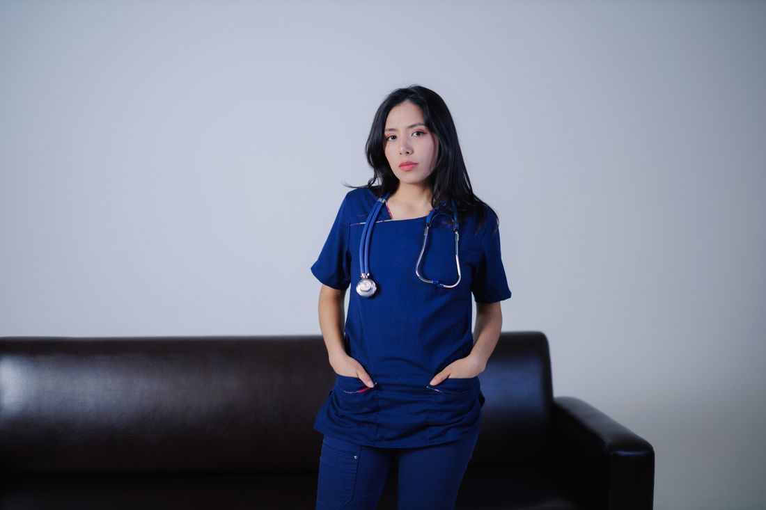 A nurse standing quietly at the end of a long shift