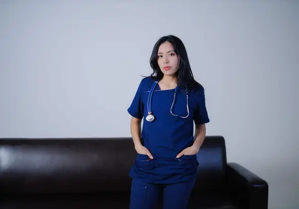 A nurse standing quietly at the end of a long shift