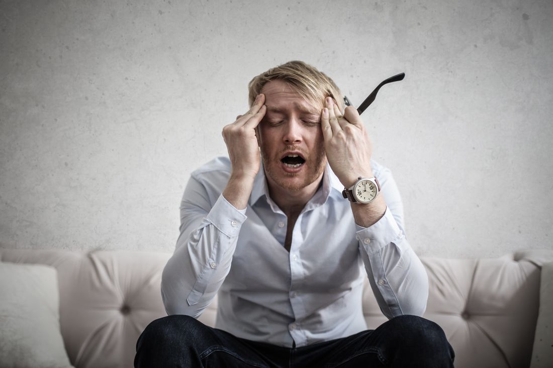 A weary man with his head in his hands
