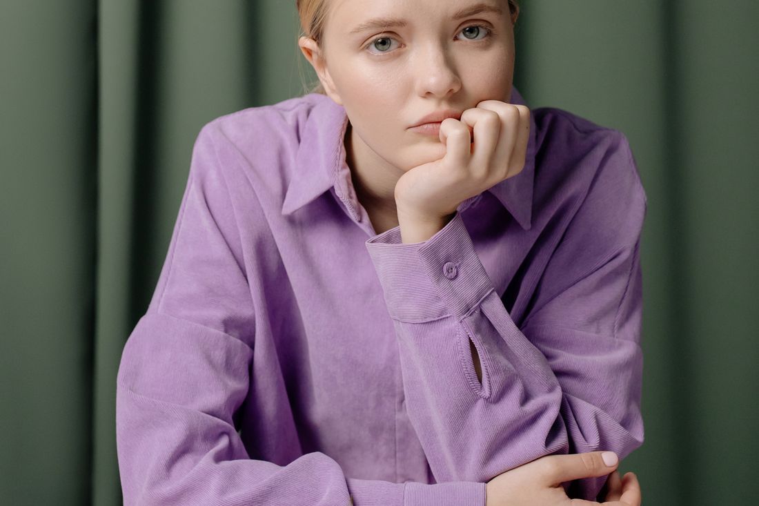 A young woman lost in thought, hand at her chin