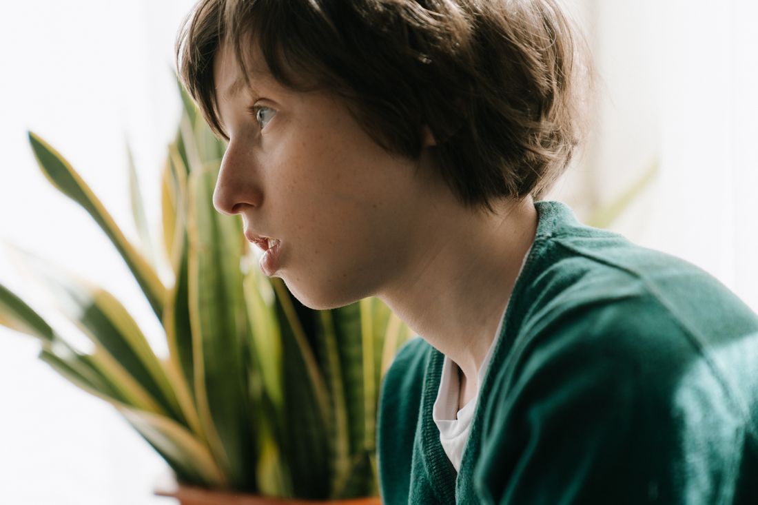 A boy gazing out a window, lost in thought