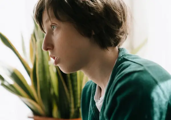A boy gazing out a window, lost in thought