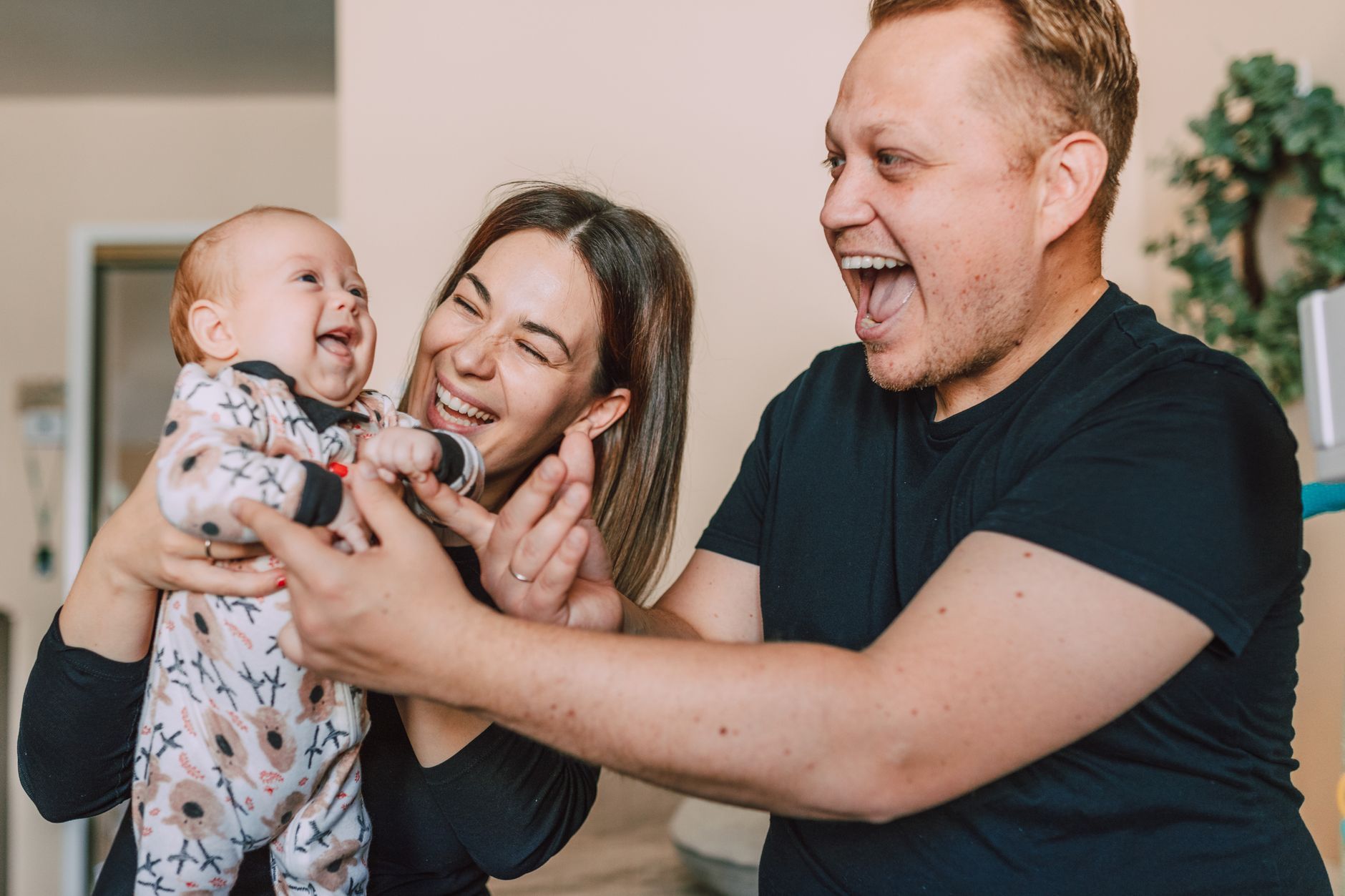 A young Italian family laughing with their baby