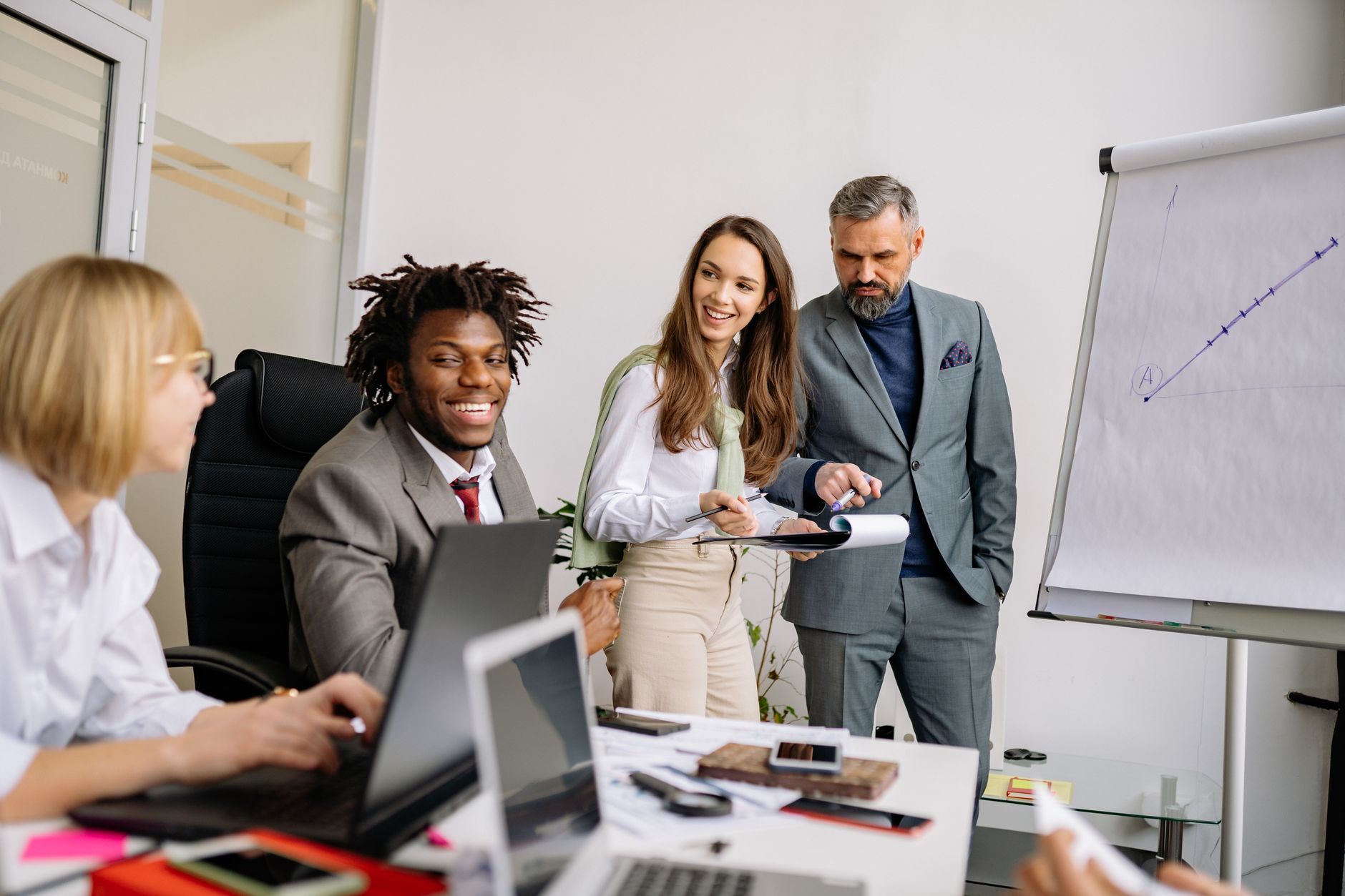 A mentor guiding a diverse team at a whiteboard