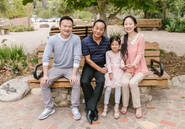 A joyful Hong Kong family on a park bench