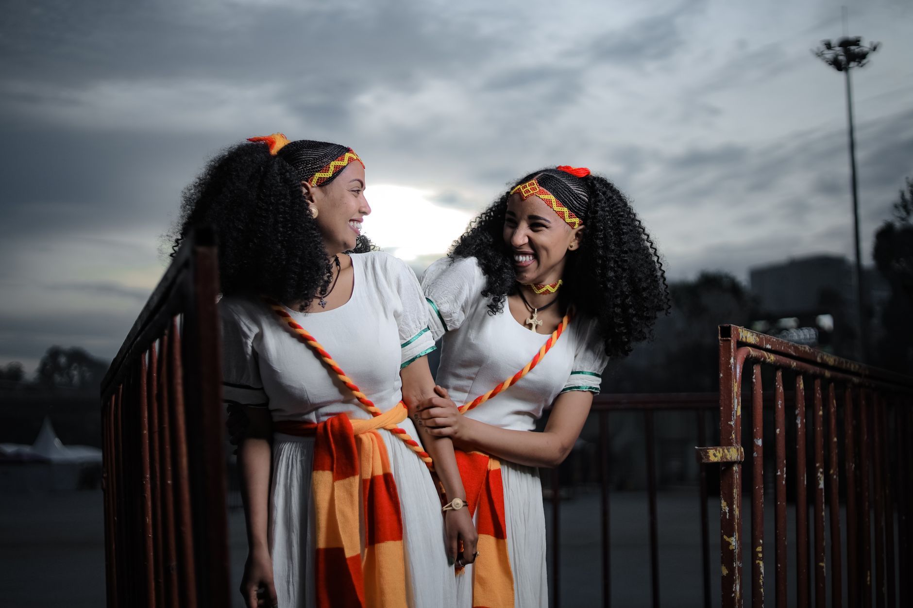 Two Ethiopian women in traditional dress, laughing together