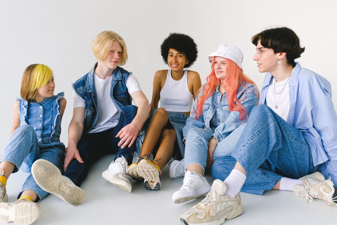 A group of teenage friends sitting together, relaxed and happy