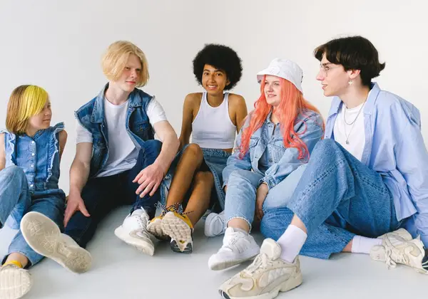 A group of teenage friends sitting together, relaxed and happy