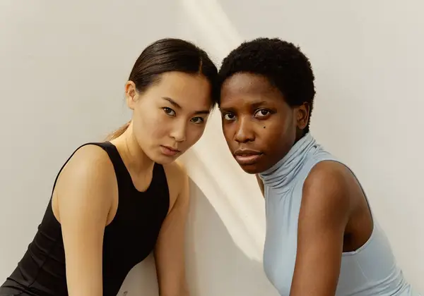 Two women resting forehead to forehead in quiet solidarity