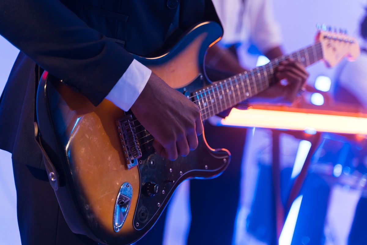 A guitarist playing electric guitar on a worship stage
