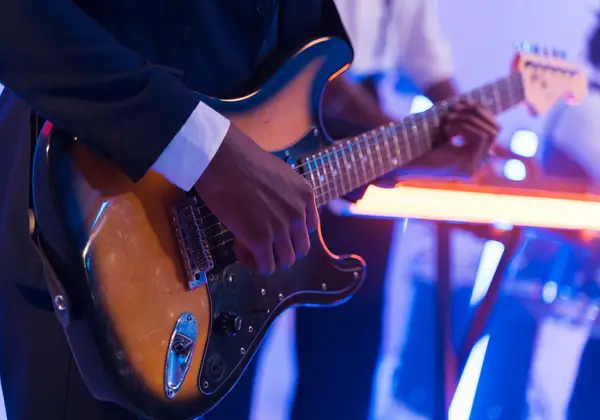 A guitarist playing electric guitar on a worship stage