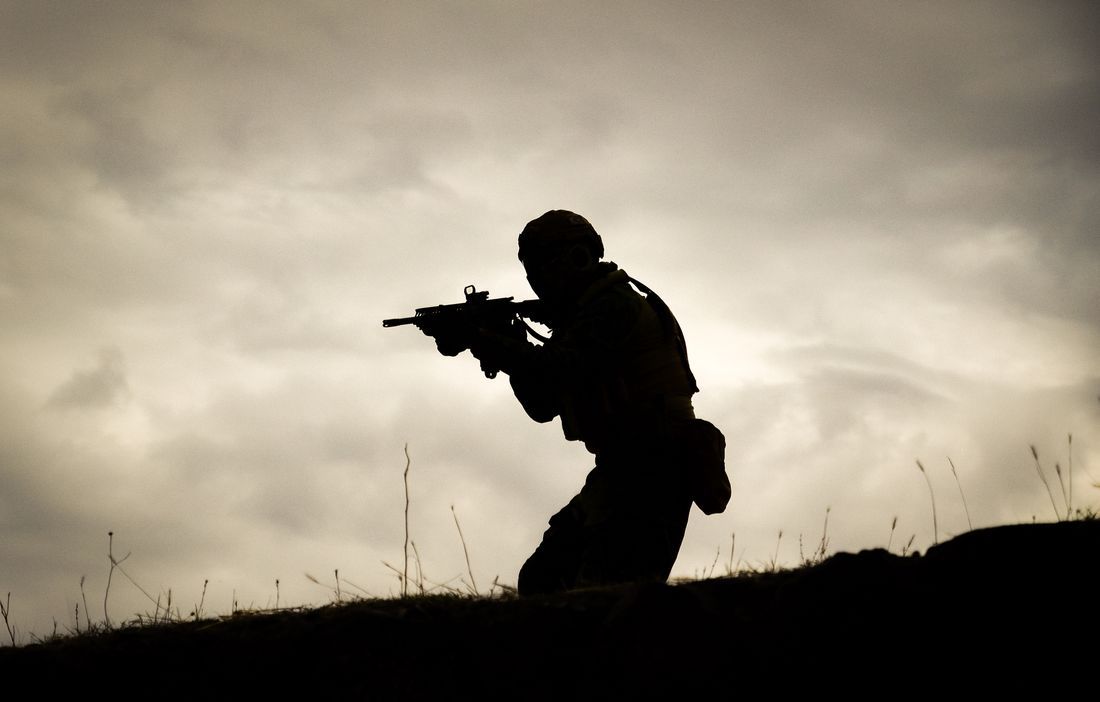 The silhouette of a soldier against a darkening sky
