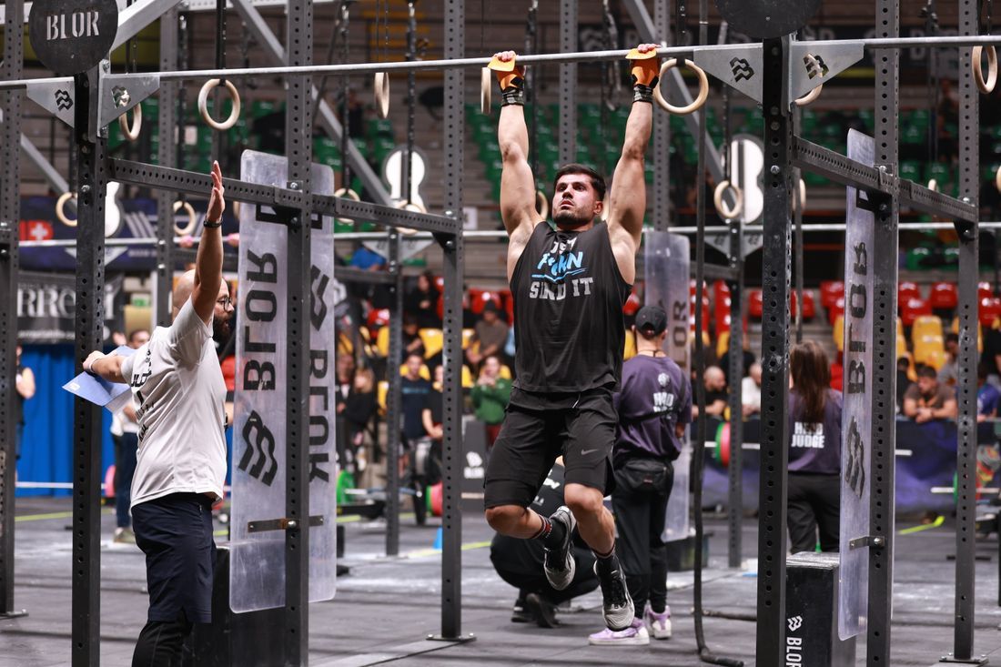 An athlete straining through a strength hold in competition
