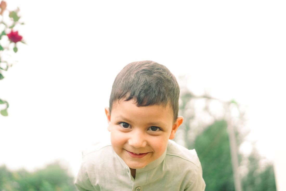 A young boy smiling brightly in soft light