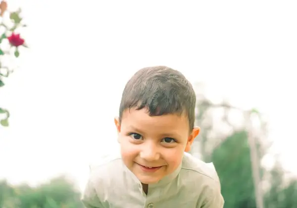 A young boy smiling brightly in soft light
