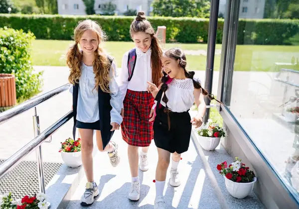 Three middle school girls walking and laughing together